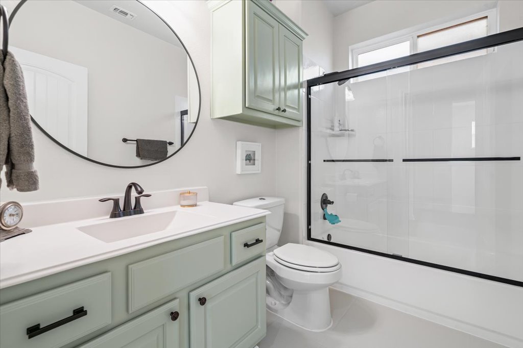 5912 Corrine Lane Austin, TX 78747 - Photo 17 of 27 Bathroom featuring vanity, shower / bath combination with glass door, and tile patterned flooring