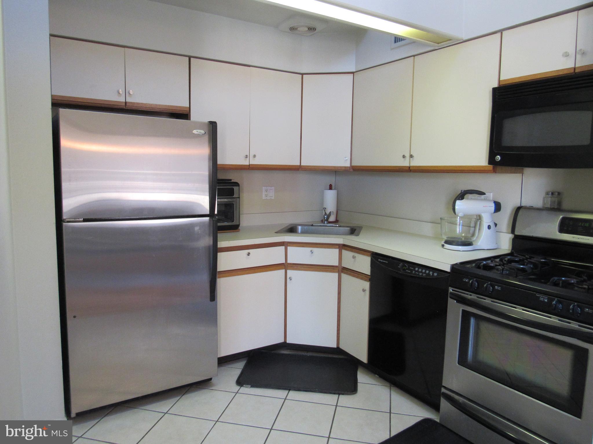 9585 James Street, Unit B Philadelphia, PA 19114 - Photo 8 of 26 a kitchen with granite countertop a sink stove and refrigerator