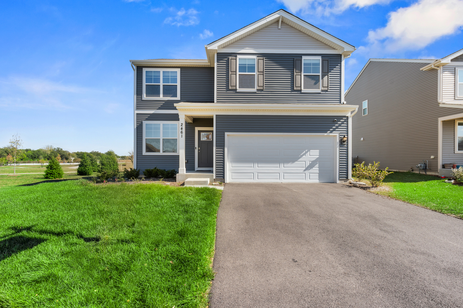 a front view of a house with a garden and garage