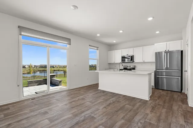 a kitchen with a refrigerator and wooden floor