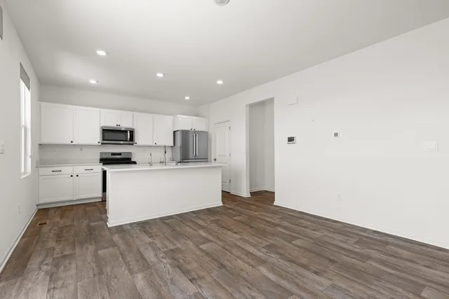 a view of kitchen with granite countertop cabinets and refrigerator