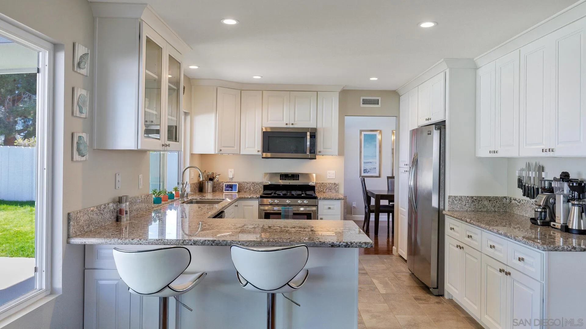 388 Compass Road Oceanside, CA 92054 - Photo 4 of 15 a kitchen with stainless steel appliances granite countertop a refrigerator a stove a sink a dining table and chairs