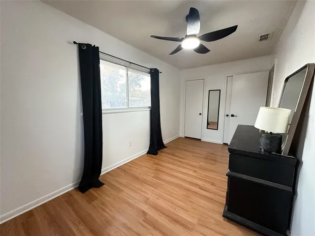 a bed room with a bed and a ceiling fan
