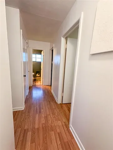 a view of a hallway with wooden floor