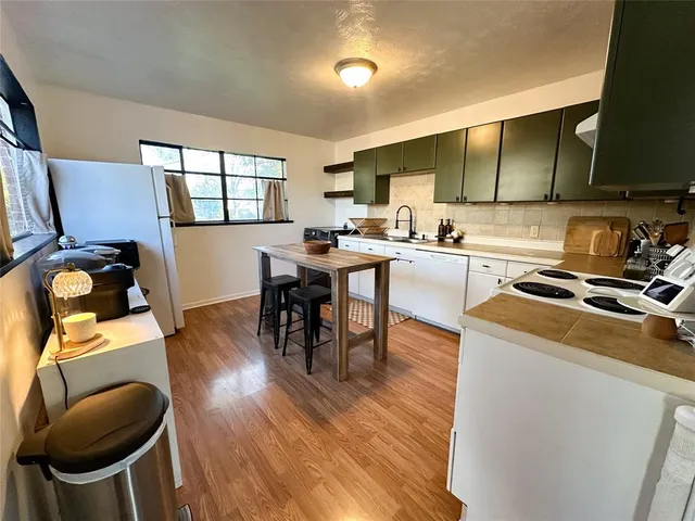 a kitchen with a table chairs and a wooden floor