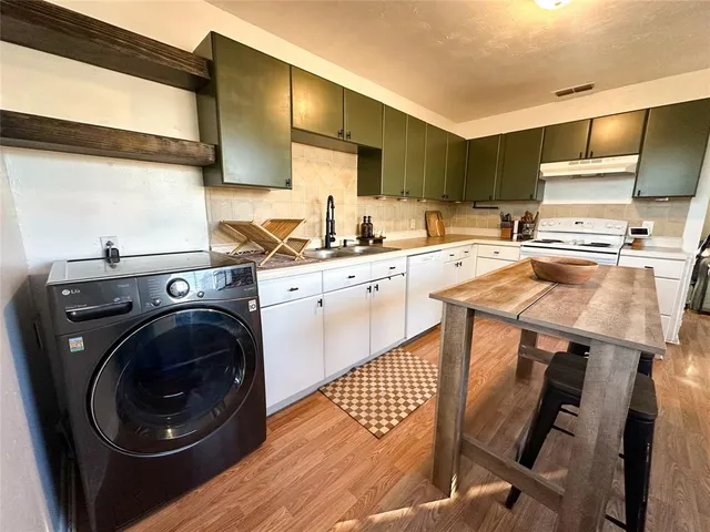 a kitchen with a sink a stove and cabinets