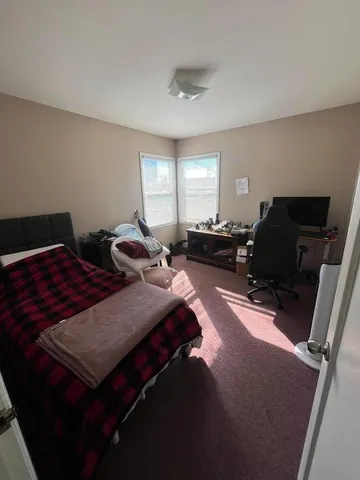 a bed sitting in a bedroom next to a window