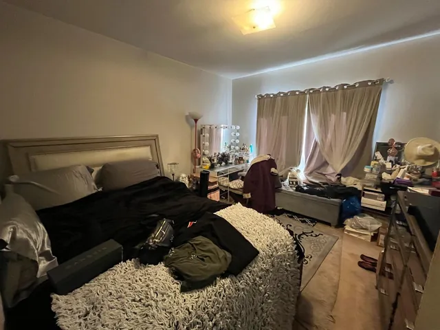 a bed room with a bed a couch and a window