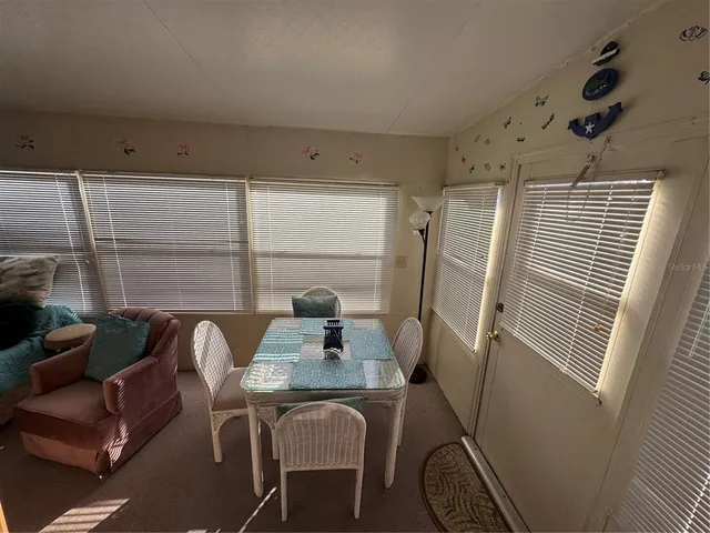 a living room with furniture kitchen view and large windows
