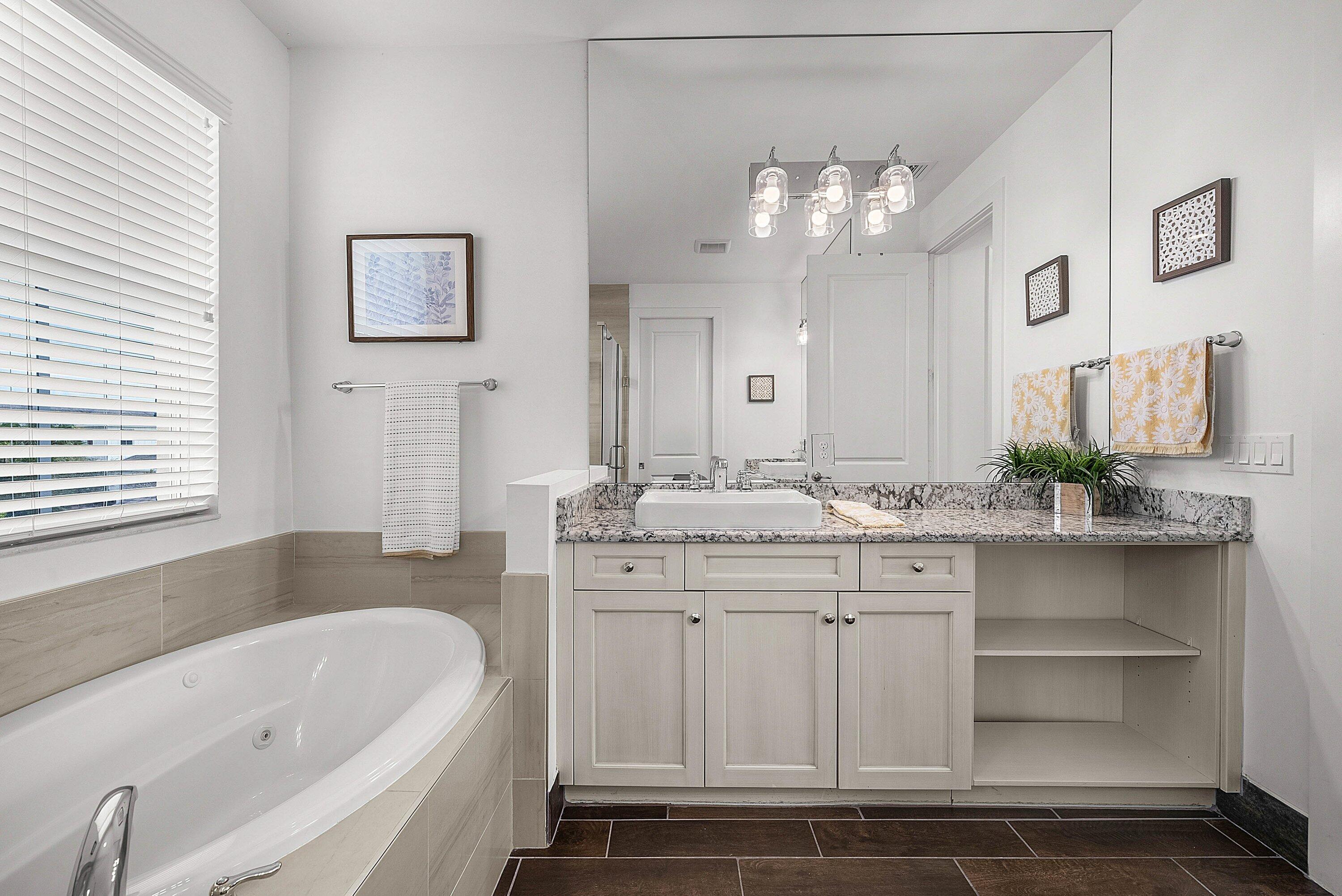 1107 Timber Reap Trail Loxahatchee, FL 33470 - Photo 30 of 83 a bathroom with a granite countertop sink a large mirror and a bathtub