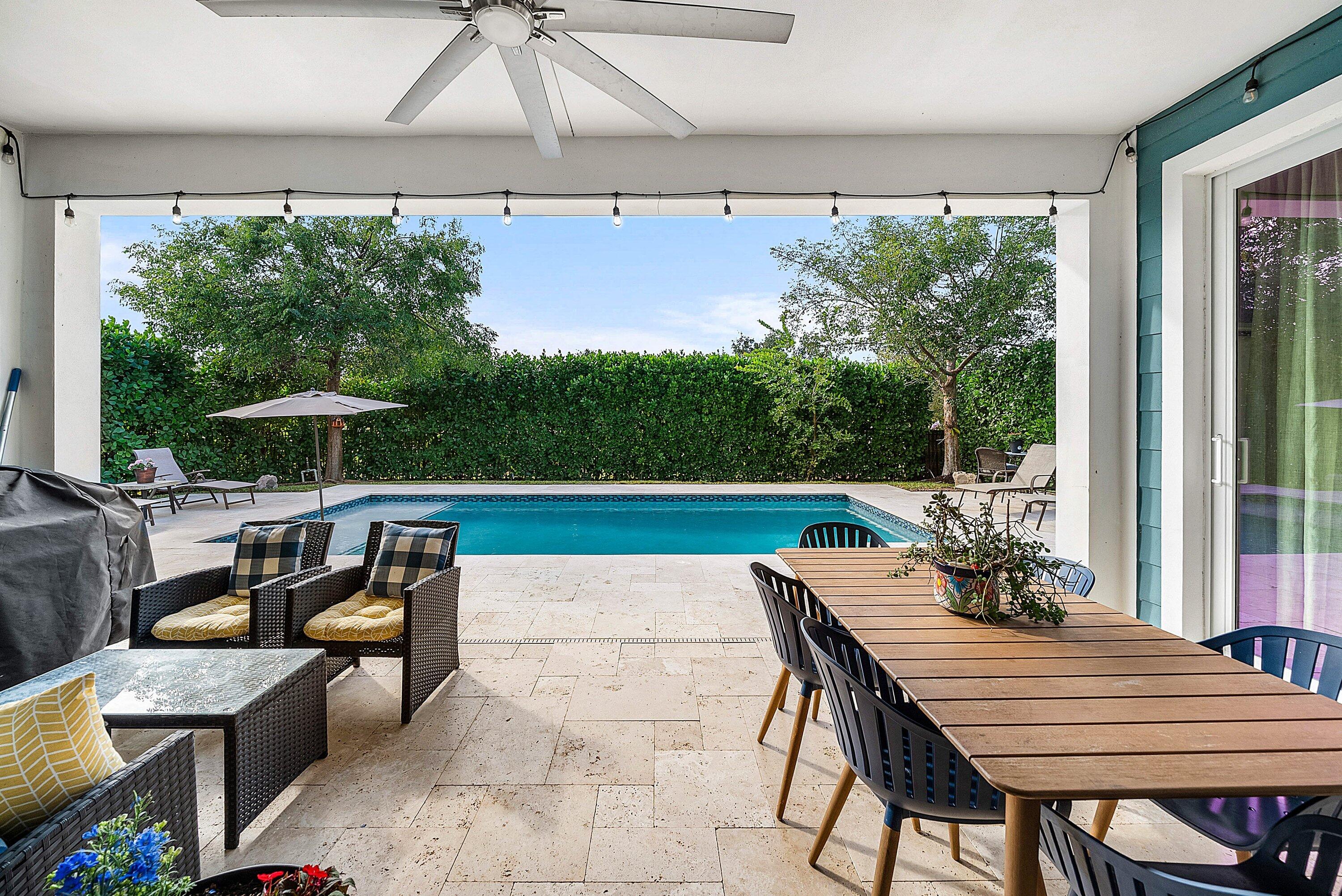 1107 Timber Reap Trail Loxahatchee, FL 33470 - Photo 36 of 83 a view of a patio with a dining table and chairs under an umbrella