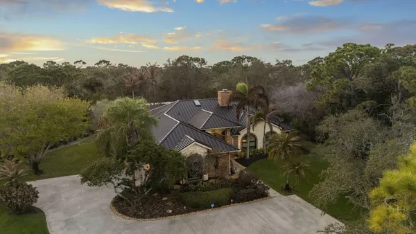 a view of a patio with a table and chairs under an umbrella