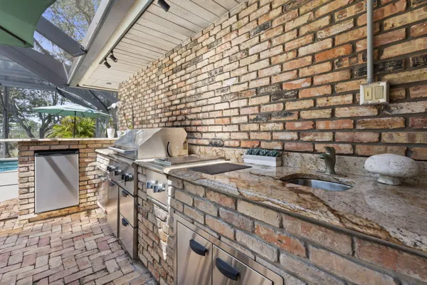 a kitchen with stainless steel appliances granite countertop a stove top oven a sink a dining table and chairs