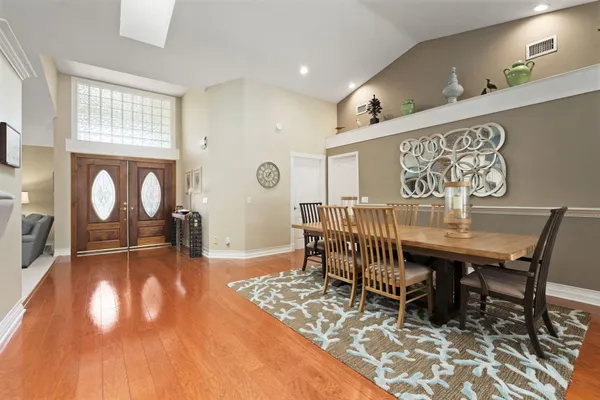 a spacious bedroom with a bed a mirror on dresser and a flat screen tv
