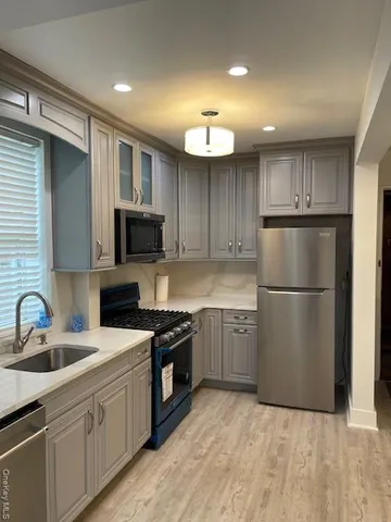 a kitchen with a sink stainless steel appliances and cabinets