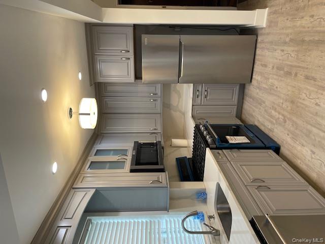 138-28 77th Avenue, Unit 64C Queens, NY 11367 - Photo 2 of 12 a kitchen with a sink stainless steel appliances and cabinets