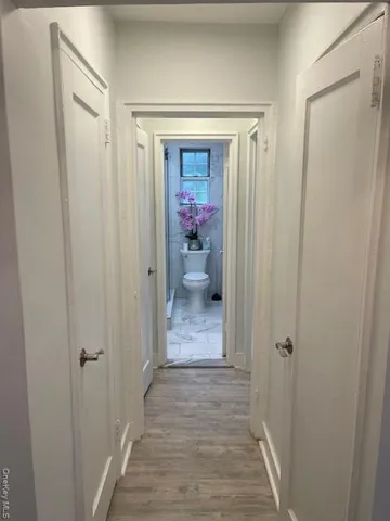 a view of a hallway view with wooden floor and closet