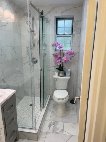a bathroom with a toilet and a shower