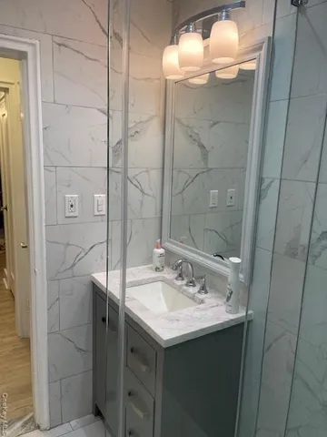 a bathroom with a sink shower and a mirror