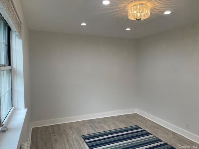 138-28 77th Avenue, Unit 64C Queens, NY 11367 - Photo 9 of 12 a view of an empty room with wooden floor and a window
