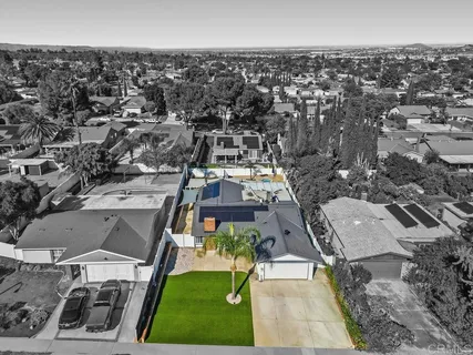an aerial view of residential houses with outdoor space and parking