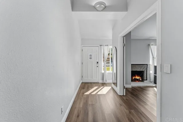 a kitchen with stainless steel appliances granite countertop a stove a sink a refrigerator and white cabinets with wooden floor