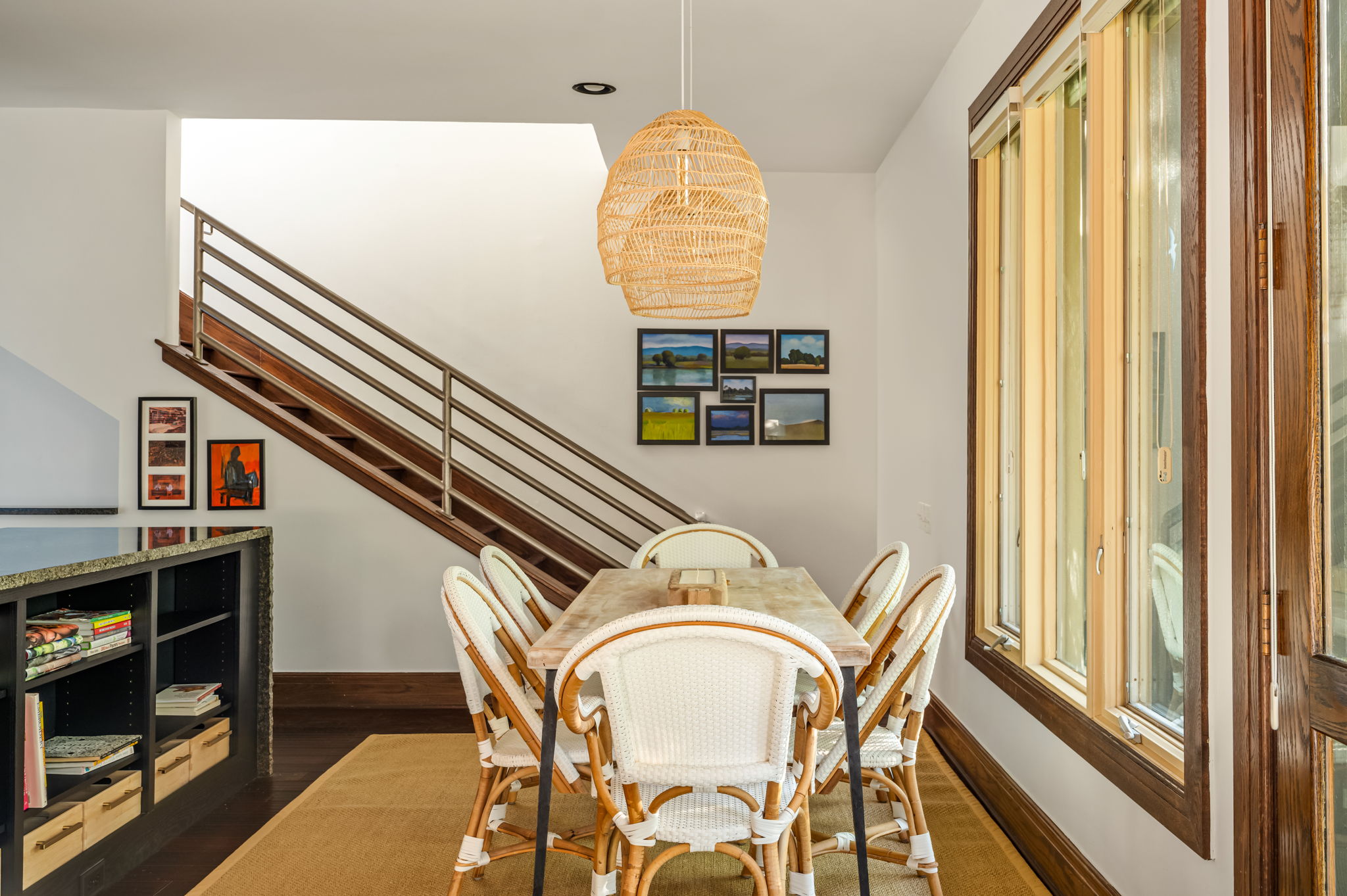 1111 West 12th Street, Unit 107 Austin, TX 78703 - Photo 24 of 38 Open-concept area featuring a dining space with a woven pendant light, a modern staircase with wood treads and metal railing, dark wood-finish flooring, and large multi-pane windows with dark wood trim