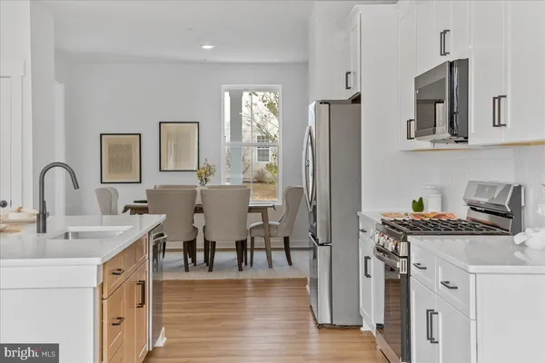 a kitchen with stainless steel appliances white cabinets and refrigerator