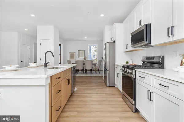 a large kitchen with stainless steel appliances granite countertop a lot of counter space and wooden floor