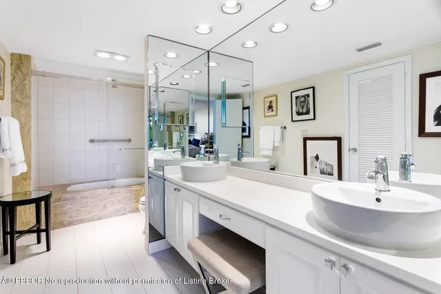 a spacious bathroom with a sink a large mirror and a shower