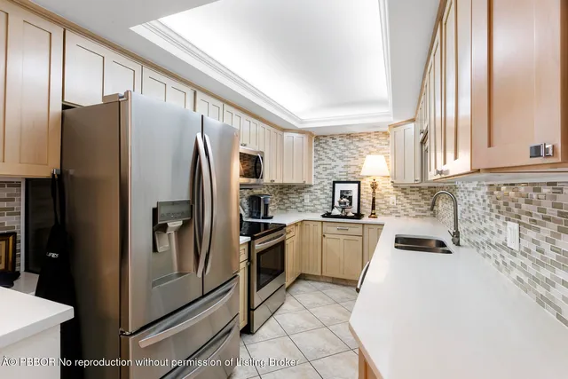 a kitchen with granite countertop stainless steel appliances a refrigerator a stove top oven and sink