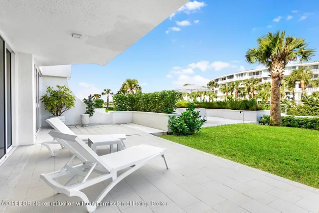 a view of a patio with couches and table and chairs and potted plants