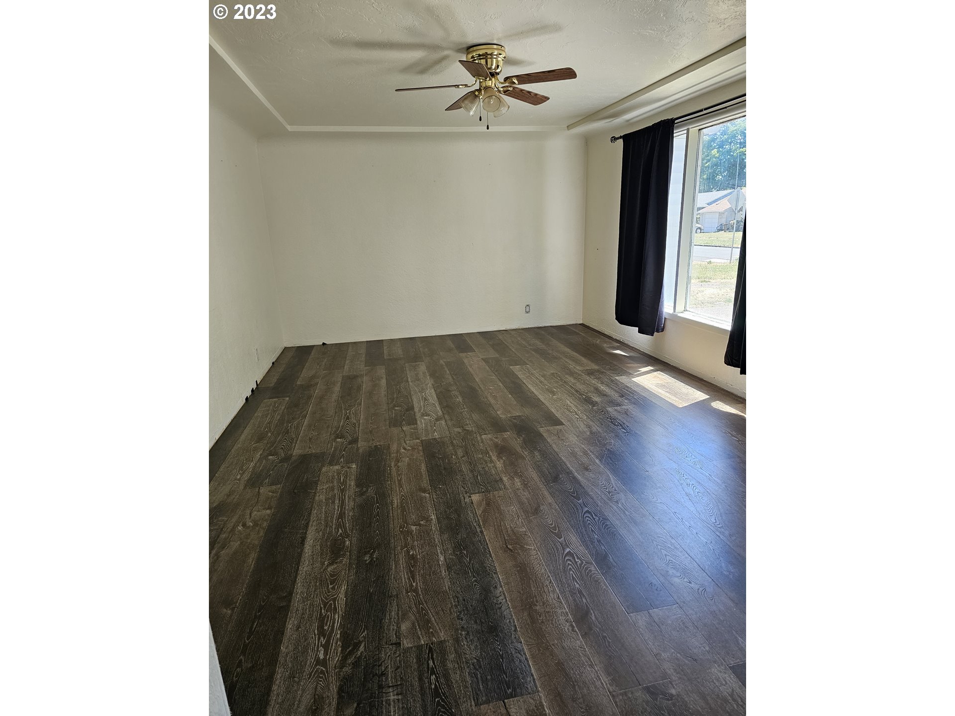 1278 M Street Springfield, OR 97477 - Photo 3 of 13 a view of a hallway with wooden floor and a ceiling fan