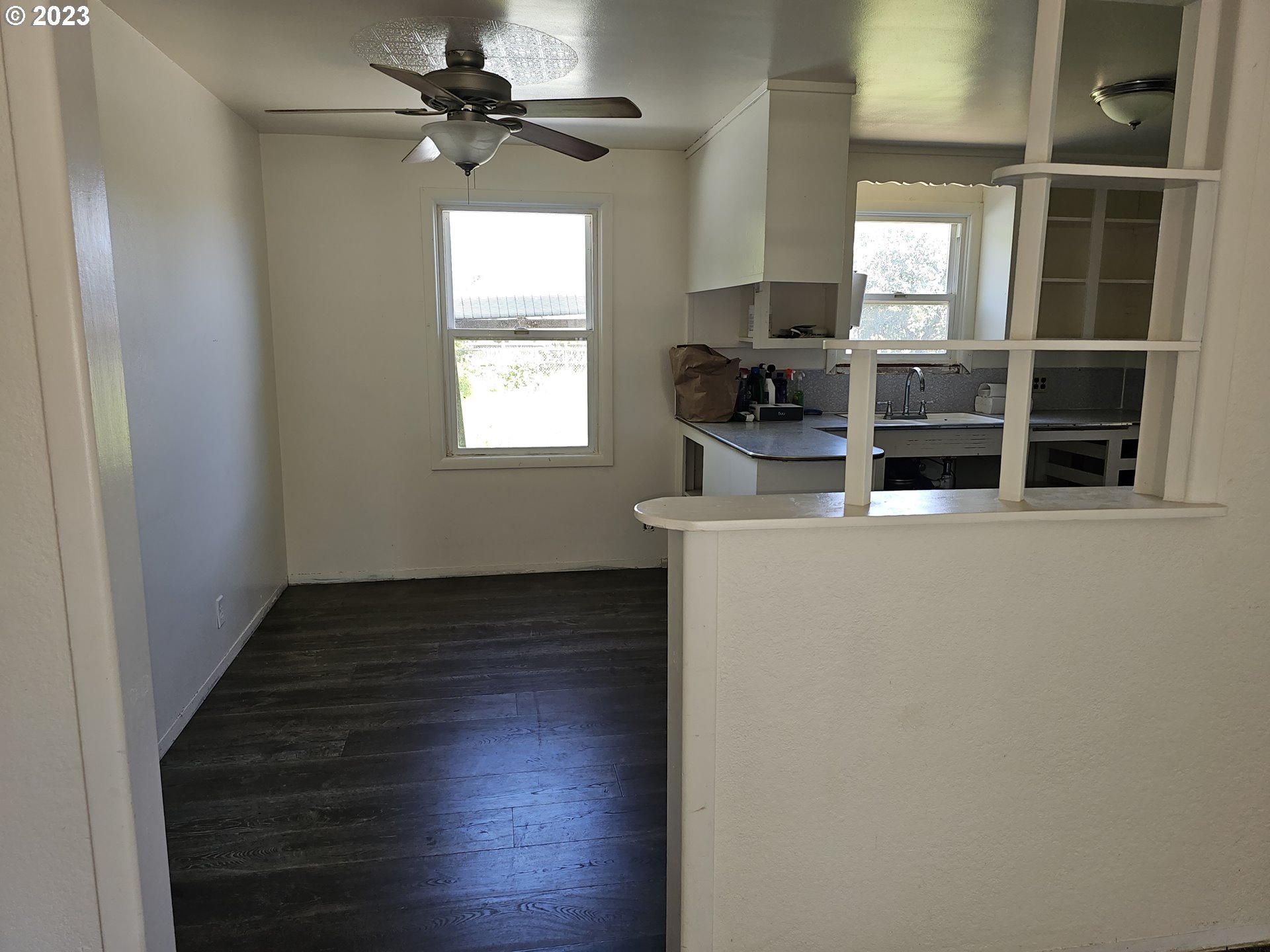 1278 M Street Springfield, OR 97477 - Photo 4 of 13 an empty room with wooden floor cabinet and windows