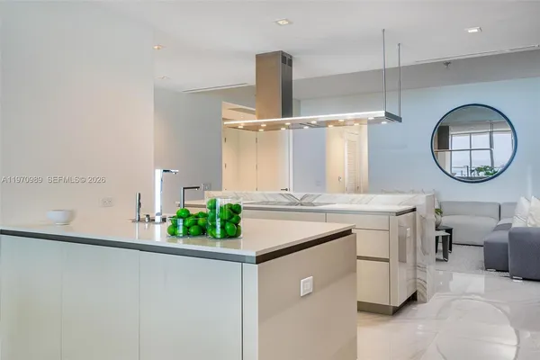 a kitchen with kitchen island a stove a sink and a chandelier