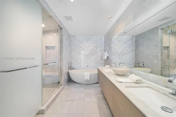 a bathroom with a tub sink and mirror