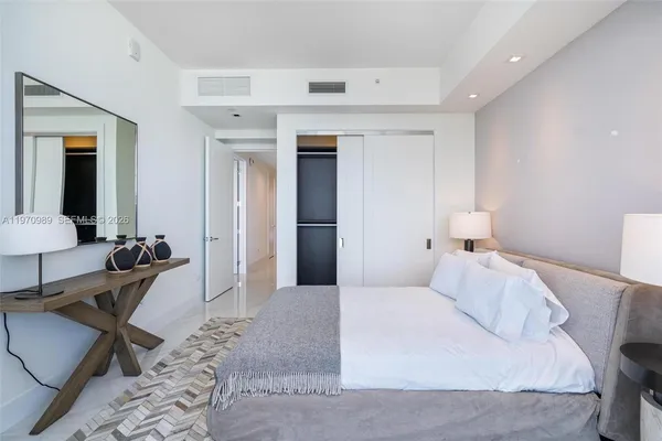 a bedroom with a bed a couch and a walk in closet