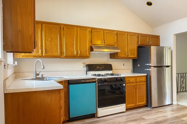 a kitchen with stainless steel appliances granite countertop a sink stove and refrigerator