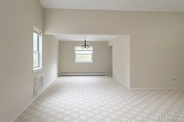 an empty room with windows and chandelier