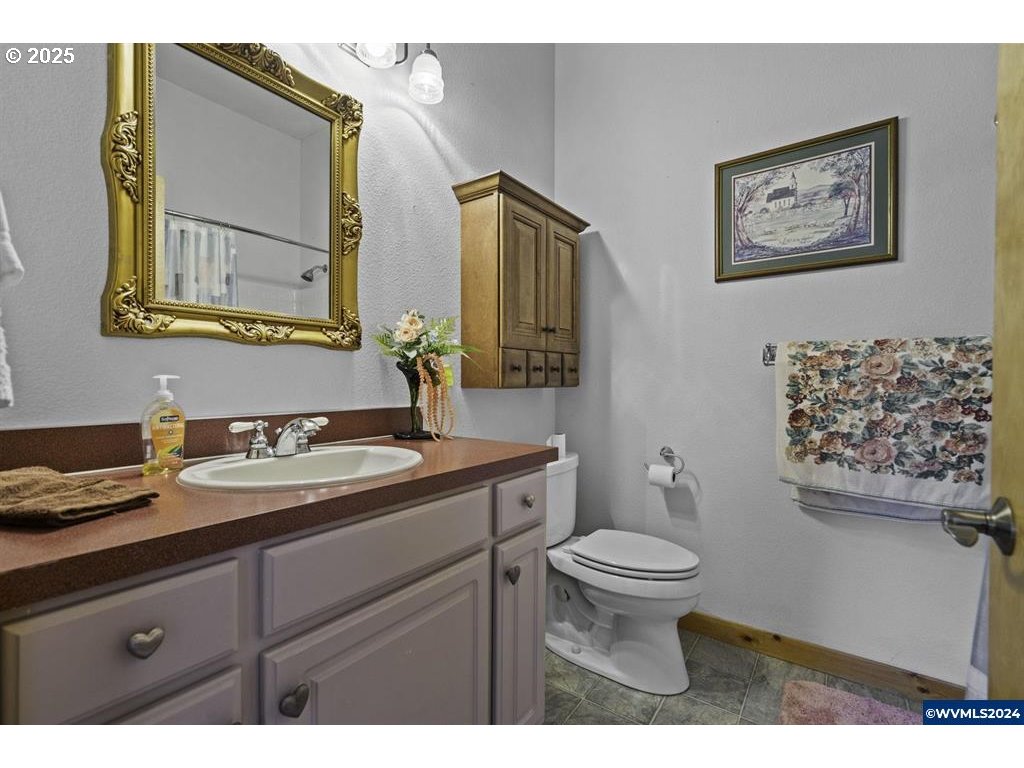 5465 Sams Place Southeast Turner, OR 97392 - Photo 28 of 46 a bathroom with a granite countertop toilet sink and mirror