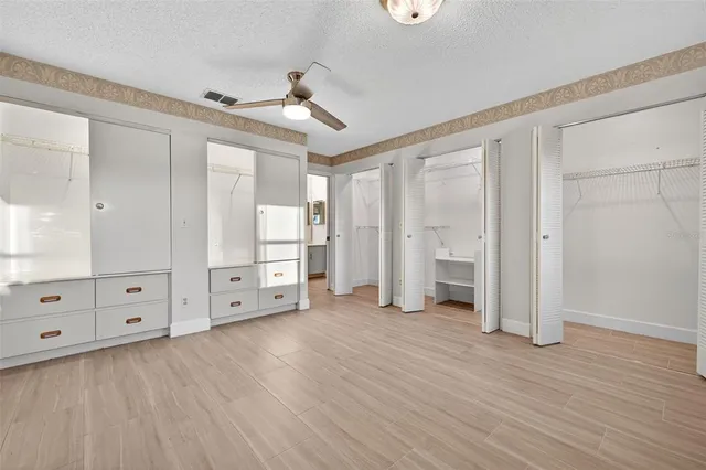 a view of an empty room with wooden floor and cabinet