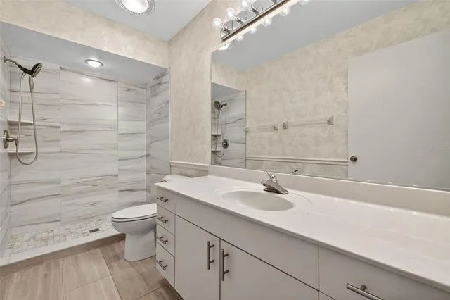 a bathroom with a sink a toilet and shower