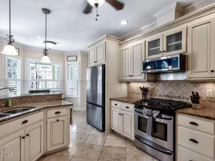 a kitchen with stainless steel appliances granite countertop a stove a refrigerator and a microwave