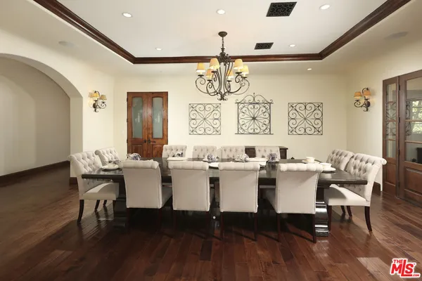 a dining room with furniture a chandelier and wooden floor