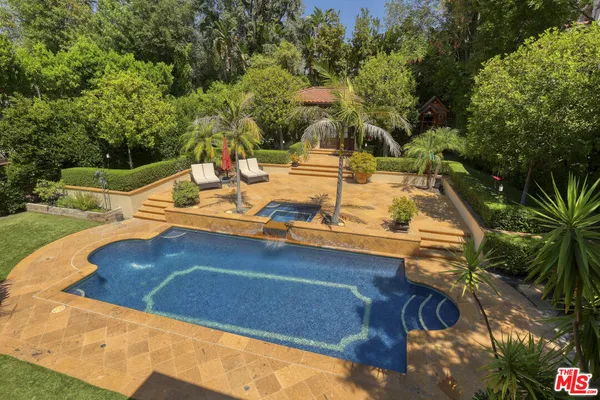 a view of a white house with a yard and a large tree