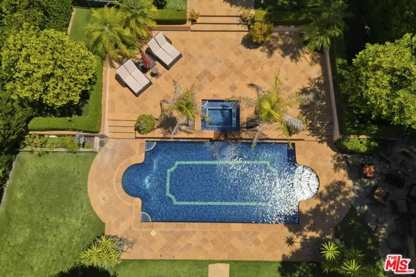 a view of a white house with a yard patio and a fountain