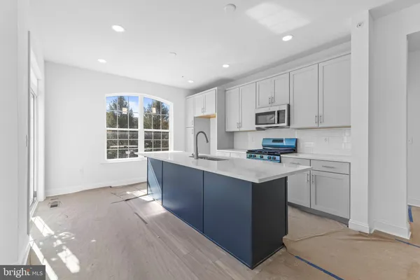 a kitchen with kitchen island granite countertop appliances cabinets and a sink