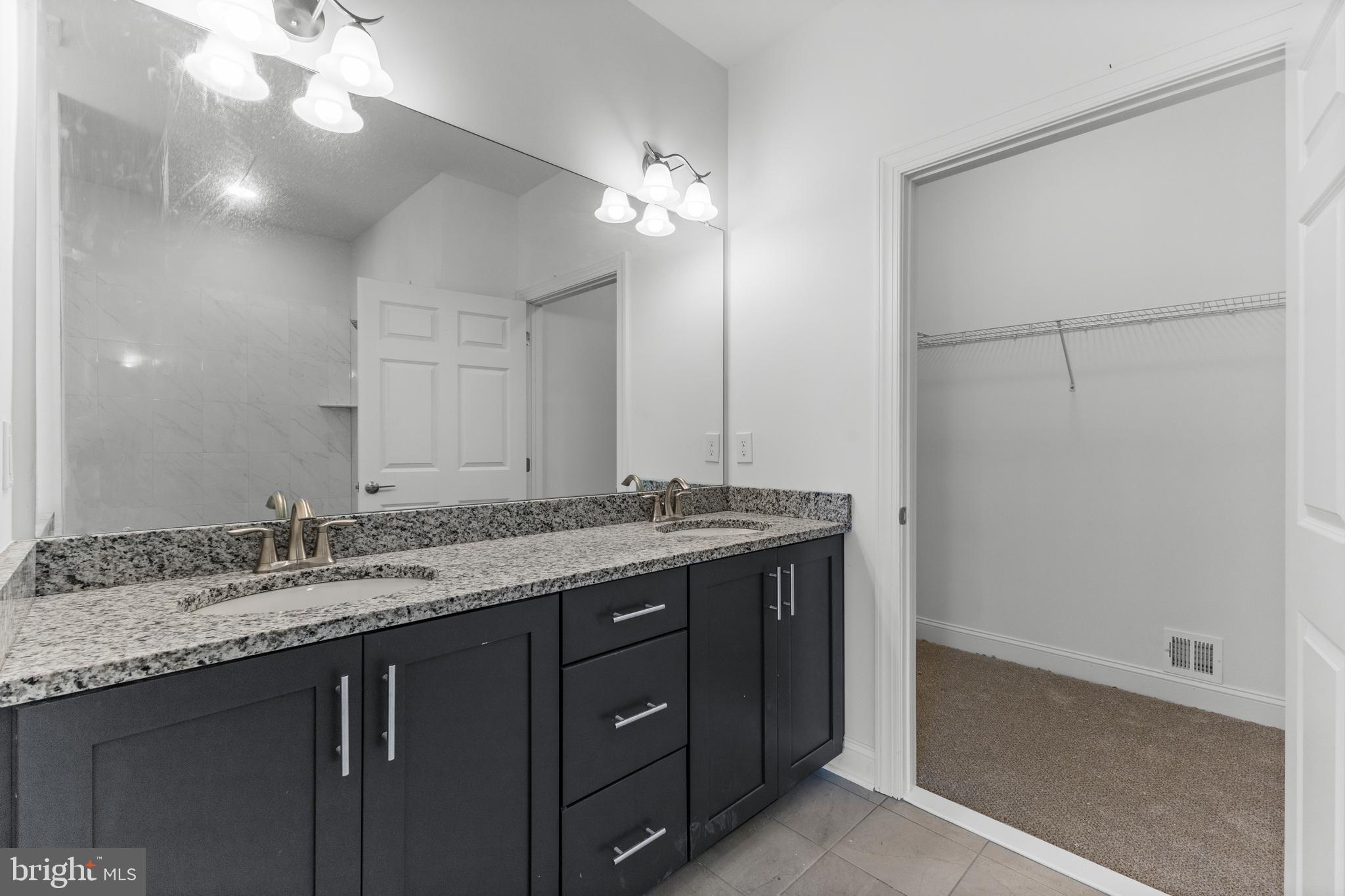 868 Veneto Court, Unit 66 Easton, PA 18040 - Photo 19 of 37 a bathroom with a granite countertop sink and a mirror