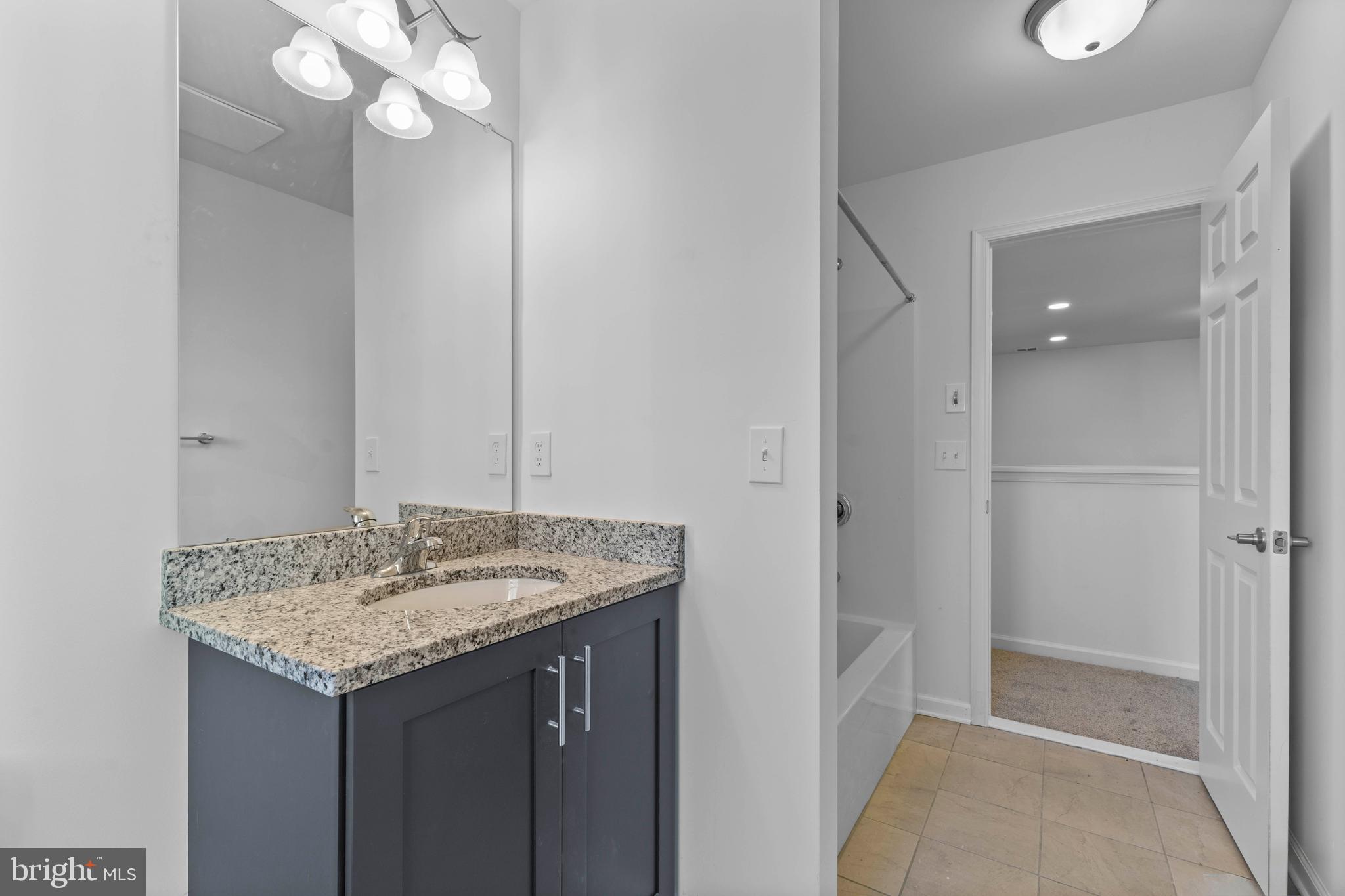868 Veneto Court, Unit 66 Easton, PA 18040 - Photo 25 of 37 a bathroom with a granite countertop sink and a mirror