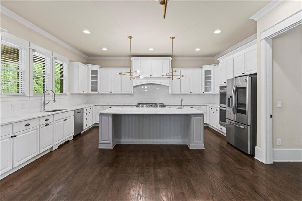 2996 Cambridge Hill Drive Dacula, GA 30019 - Photo 18 of 49 a large kitchen with stainless steel appliances kitchen island a large counter top and a stove top oven
